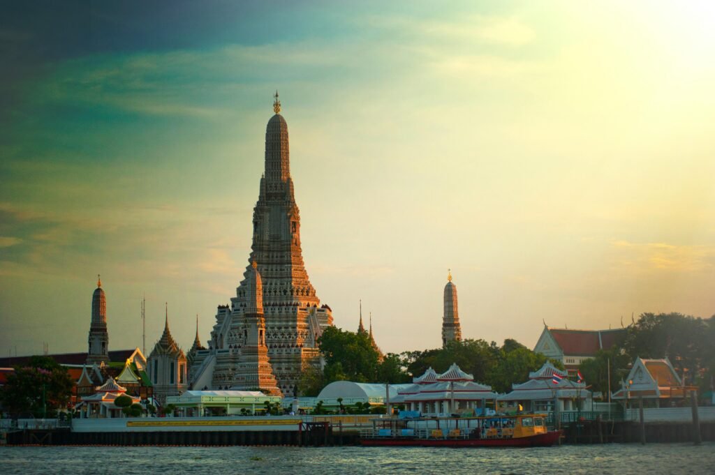 3 Days in Bangkok Itinerary: Temples, Markets & Rooftops Stunning sunset view of Wat Arun temple by the Chao Phraya River in Bangkok, Thailand.